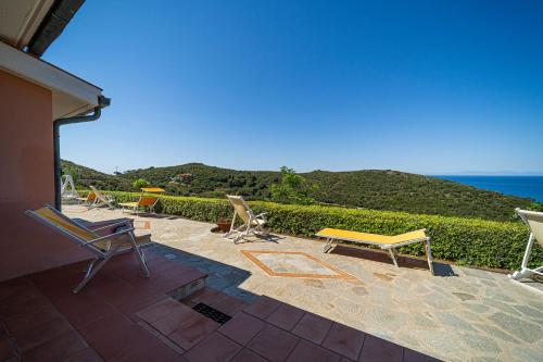 a patio with chairs and a view of the ocean at Appartamenti Vista Mare - Goelba in Capoliveri