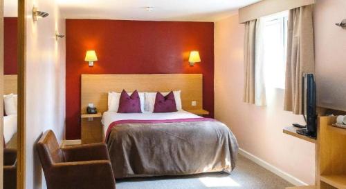 Un pat sau paturi într-o cameră la OYO Luton Hotel