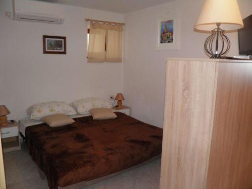 a bedroom with a bed in a room with a lamp at Apartman DEJO in Mošćenička Draga