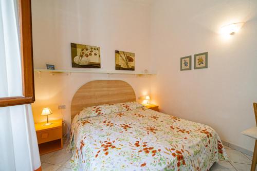a bedroom with a bed and two tables and two lamps at Appartamenti Vista Mare - Goelba in Capoliveri