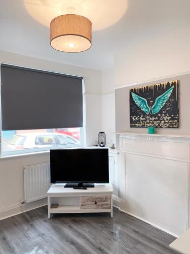 a living room with a flat screen tv on a table at The Baltic Townhouses by Serviced Living Liverpool in Liverpool