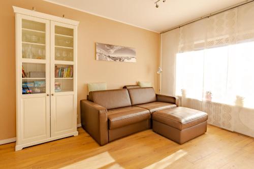 uma sala de estar com um sofá de couro e uma janela em Kuthe em Sonthofen