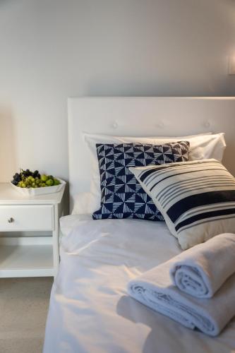 a white bed with pillows and a bowl of fruit on a table at Hvar Old Dalmatian House Junior Suite - Deck 2 in Hvar