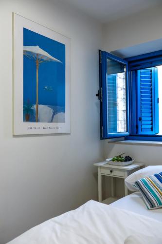 a bedroom with a bed and a picture of an umbrella at Hvar Old Dalmatian House Junior Suite - Deck 3 in Hvar