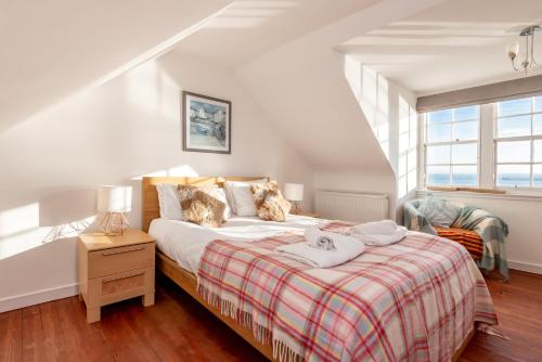 a bedroom with a bed with a red and white blanket at Shore House, Stunning Sea Views, Parking in Pittenweem