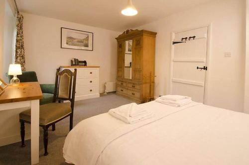 a bedroom with a bed and a desk and a chair at Woodland Crag Cottage, Grasmere in Grasmere