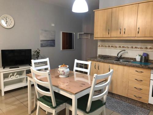 a kitchen with a wooden table and chairs and a sink at LAS CALMAS in La Restinga