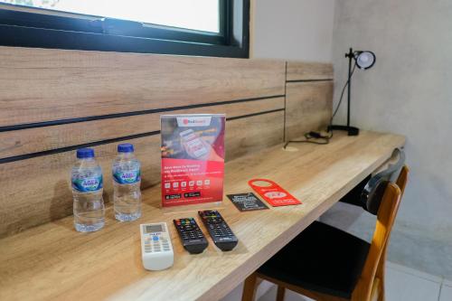 a table with two bottles of water and remote controls at RedDoorz near Trans Studio Mall Cibubur 3 in Bogor