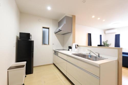 a kitchen with a sink and a refrigerator at 5 minutes Shin-Osaka 3 in Osaka