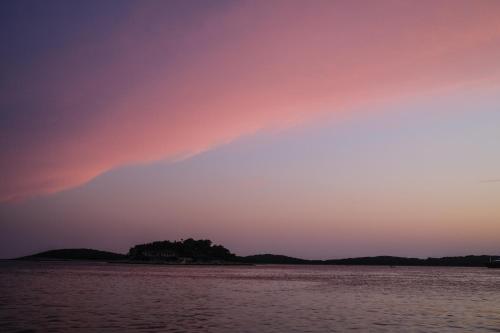 a rainbow in the sky over a body of water at Hvar Old Dalmatian House Junior Suite - Deck 3 in Hvar