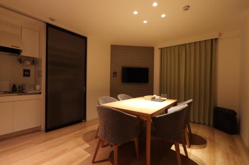 a dining room with a wooden table and chairs at 5 minutes Shin-Osaka 9 in Osaka