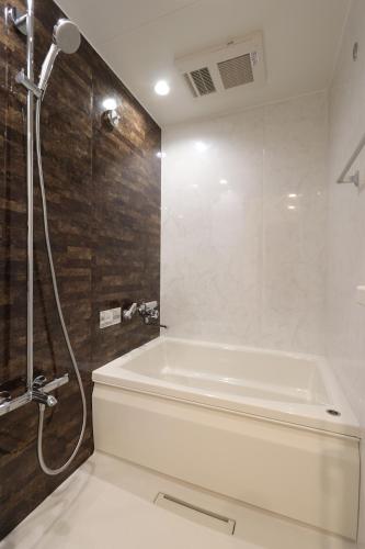 a bathroom with a white tub and a shower at 5 minutes Shin-Osaka 9 in Osaka