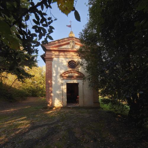 an old building with a cross on top of it at Villa Curina Resort in Castelnuovo Berardenga