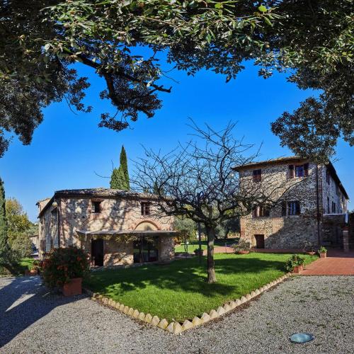 an old stone building with a tree in front of it at Villa Curina Resort in Castelnuovo Berardenga