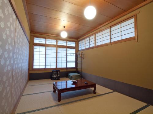 an empty room with a table and windows at Koyasan Shukubo Sainanin in Koyasan