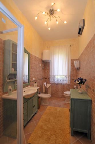 a bathroom with a sink and a toilet and a mirror at Casale Le Capanne in Cortona