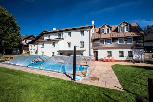 a house with a swimming pool in the yard at Penzion Barborka in Rokytnice nad Jizerou