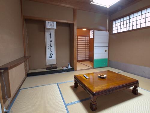 a room with a table in the middle of a room at Koyasan Shukubo Sainanin in Koyasan