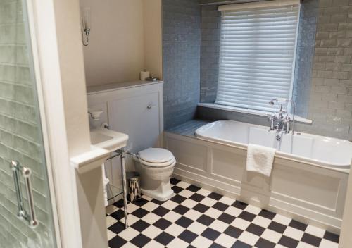a bathroom with a tub and a toilet and a sink at Edgbaston Park Hotel Birmingham in Birmingham