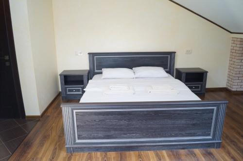 a bed in a room with two night stands at Rosinka in Ukrayinka