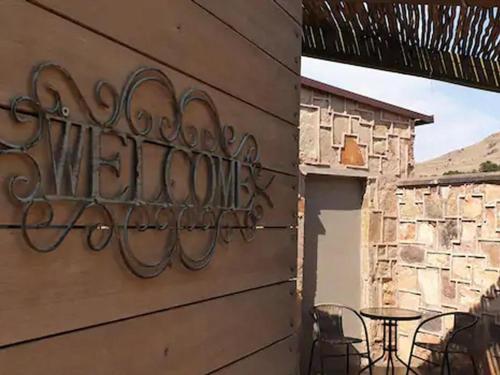 a metal sign on the side of a building with a table at Migrate Portfolio in Dullstroom