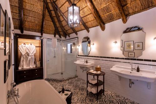 łazienka z 2 umywalkami, wanną i prysznicem w obiekcie Lalibela Game Reserve - Kichaka Lodge w mieście Paterson