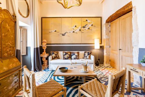 a bedroom with a bed and a table and chairs at Hotel La Torre del Canonigo - Small Luxury Hotels in Ibiza Town