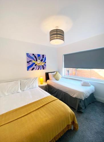 a bedroom with two beds and a window at The Baltic Townhouses by Serviced Living Liverpool in Liverpool