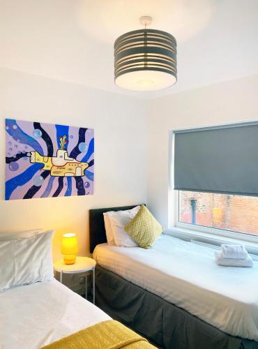 a room with two beds and a painting on the wall at The Baltic Townhouses by Serviced Living Liverpool in Liverpool