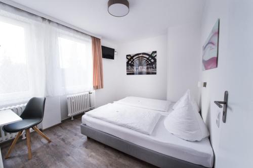 1 dormitorio con cama, escritorio y ventana en SOVA Guesthouse, en Kassel