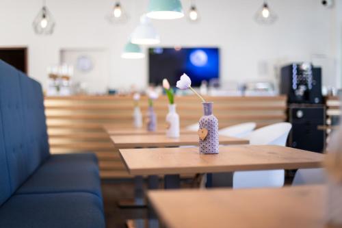eine Reihe von Tischen mit Vasen mit Blumen darauf in der Unterkunft SOVA Guesthouse in Kassel