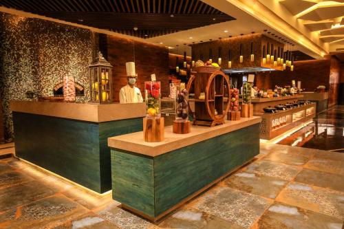 a restaurant with a counter with a chef in a kitchen at Radisson Blu Towers Kaushambi Delhi NCR in Ghaziabad