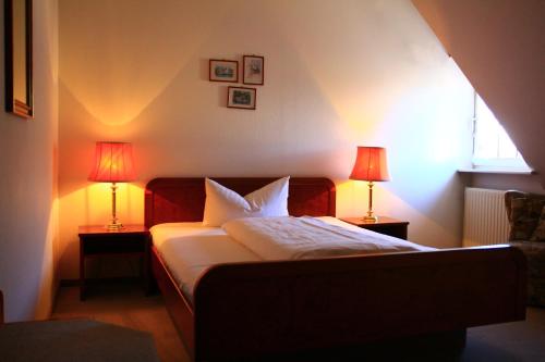 a bedroom with a bed with two lamps on two tables at Gasthaus Krone Märkt in Weil am Rhein