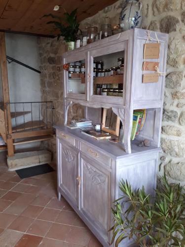 a wooden cabinet with a shelf with wine bottles at La Pierre du Grain in Ravel