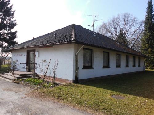 a small white house with a black roof at Land gut Hotel Dierks in Repke