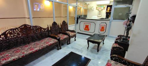 a living room with couches and a table in a room at Hotel Temple View in Madurai