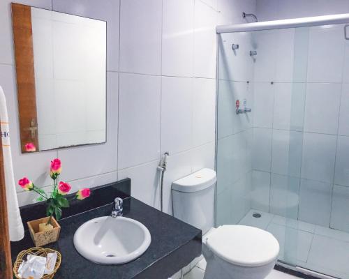 a bathroom with a toilet and a sink and a shower at Hotel Luar de Itapua in Salvador
