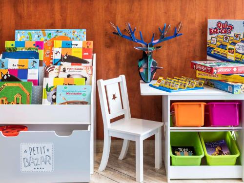 a table and a chair next to a table with toys at Aparthotel Adagio Access Paris La Villette in Paris