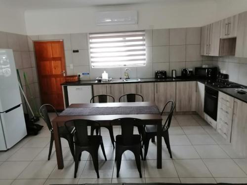 a kitchen with a table and chairs in it at 3714 @Ribbok in Marloth Park