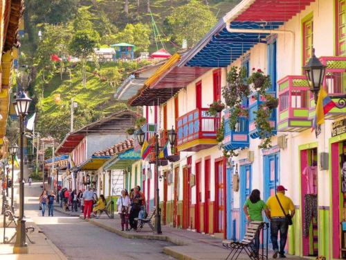 a group of people walking down a street with buildings at SAN PEDRO SALENTO Apartahotel in Salento