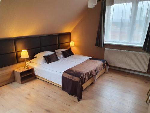 a bedroom with a large bed and a window at Károlyi Panzió in Eger