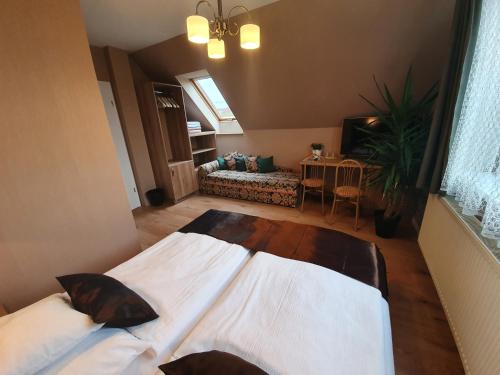 a bedroom with a large bed and a living room at Károlyi Panzió in Eger