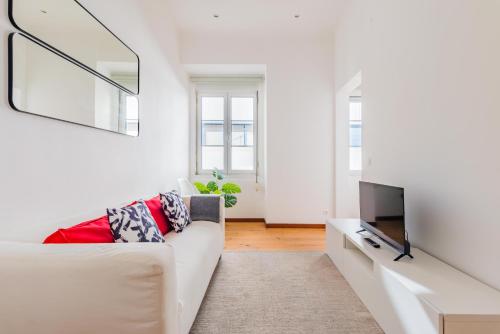 salon z białą kanapą i telewizorem w obiekcie LX Urban Living w Lizbonie