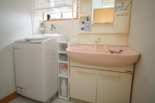 baño pequeño con lavabo y nevera pequeña en 薬水君近江八幡水郷民泊貸し切り, en Omihachiman