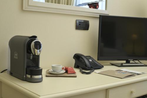 a desk with a computer and a coffee maker and a phone at Relais Bella Rosina Pool & Spa in Fiano