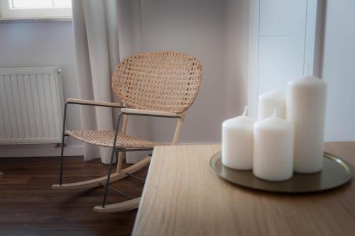 a chair and a table with white candles on it at Willa pod Lanckoroną in Izdebnik