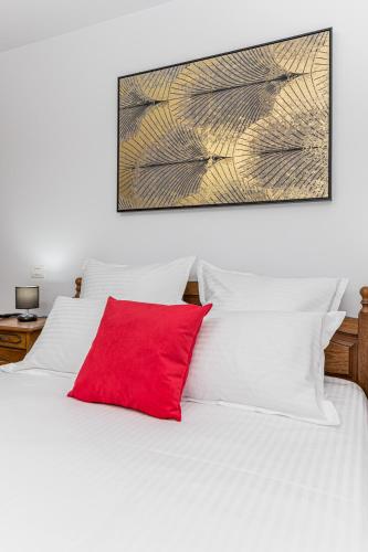 a white bed with a red pillow on it at Studio Roberta Coressi in Braşov