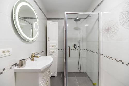 a white bathroom with a shower and a sink at Studio Roberta Coressi in Braşov