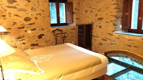 a bedroom with a bed in a room with stone walls at U Vechju Mulinu in Ortiporio
