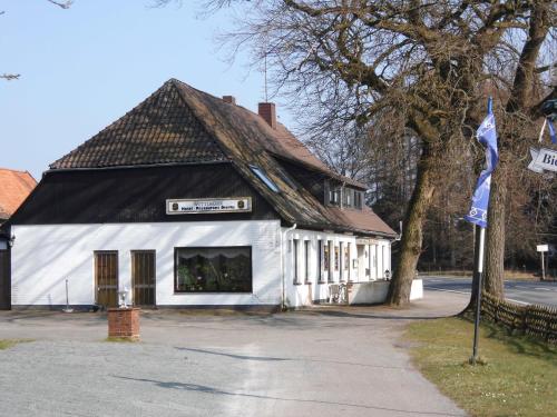 a white building with a black roof at Land gut Hotel Dierks in Repke